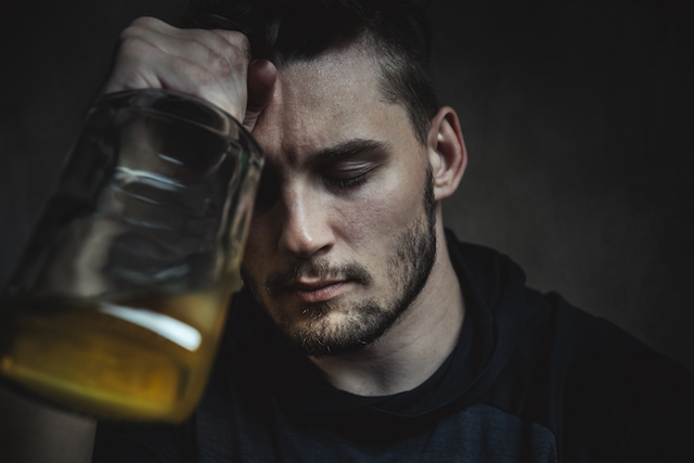 Ein Mann mit einer Alkoholsucht ist deprimiert