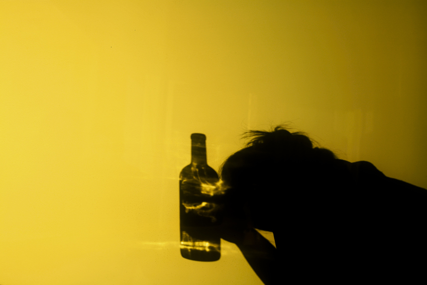 Ein Mitarbeiter mit einer Flasche Alkohol in der Hand