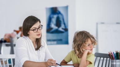 
		Eine Frau sitzt mit einem Kind am Tisch und hilft bei Hausaufgaben.
	